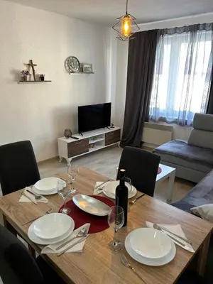 a dining room table with plates and wine glasses at Rosa Canina Kupres 2 - Centar in Kupres