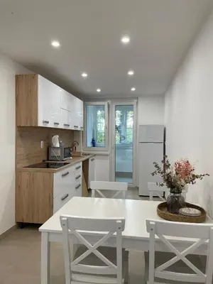a kitchen with a white table and white chairs at Apartman Rita in Livno