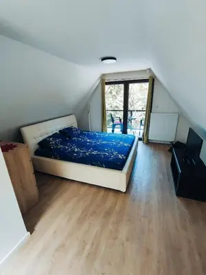 a bedroom with a bed with blue sheets on it at Vikendica Tuzla, Dolina mira in Tuzla