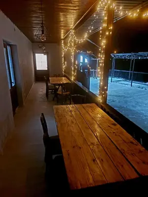 a large wooden table in a room with lights at Vikendica Tuzla, Dolina mira in Tuzla