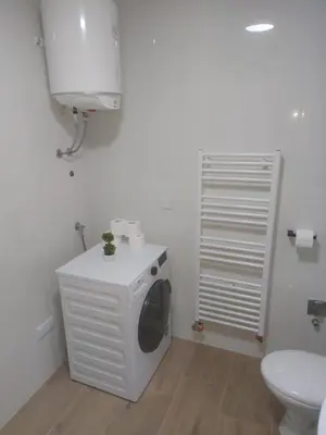 a washing machine in a bathroom with a toilet at Vikendica Tuzla, Dolina mira in Tuzla