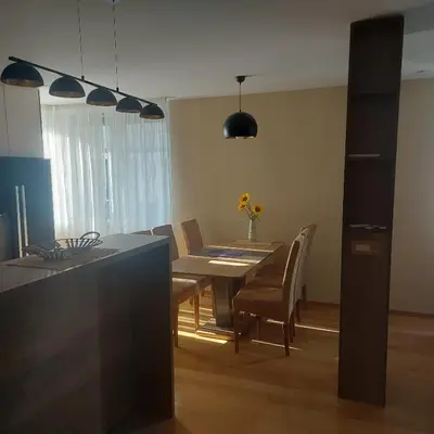 a kitchen and dining room with a table and chairs at APARTMAN CENTAR BULEVAR EX sa GARAZOM in Banja Luka