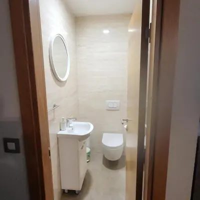 a bathroom with a toilet and a sink and a mirror at APARTMAN CENTAR BULEVAR EX sa GARAZOM in Banja Luka