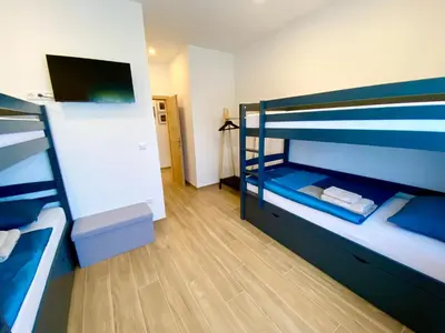 a room with two bunk beds and a flat screen tv at Visoravan 1200 in Kupres