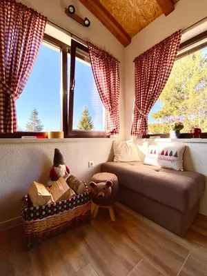 a bedroom with a bed and two windows and a couch at Visoravan 1200 in Kupres