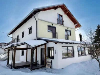 a house in the snow with a sign in front of it at Visoravan 1200 in Kupres