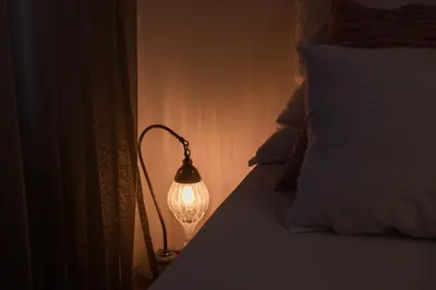 a lamp sitting next to a bed in a room at Divan Apartman u Banjaluci in Banja Luka