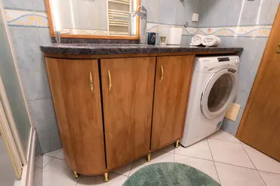 a bathroom with a sink and a washing machine at Divan Apartman u Banjaluci in Banja Luka