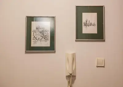 a wall with two pictures and a phone on a wall at Divan Apartman u Banjaluci in Banja Luka