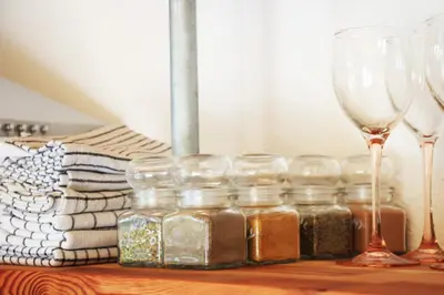 a group of glass jars and wine glasses on a table at Apartment Pirol: Dorf Hideaway Gornja Breza in Breza
