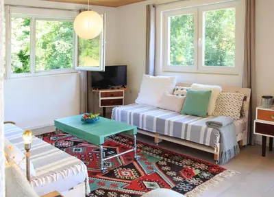 a living room with a couch and a table at Apartment Pirol: Dorf Hideaway Gornja Breza in Breza