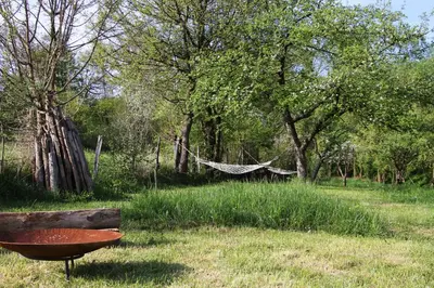 a hammock in the middle of a field with trees at Apartment Pirol: Dorf Hideaway Gornja Breza in Breza
