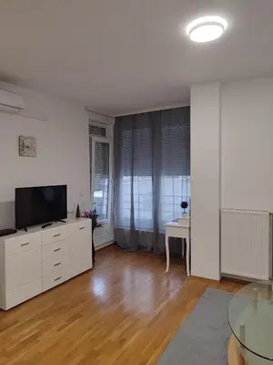 a white living room with a television and a table at Kastel in Banja Luka