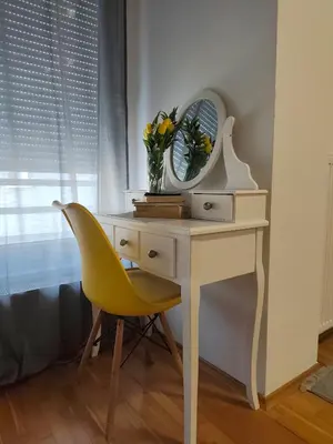 a desk with a mirror and a yellow chair at Kastel in Banja Luka