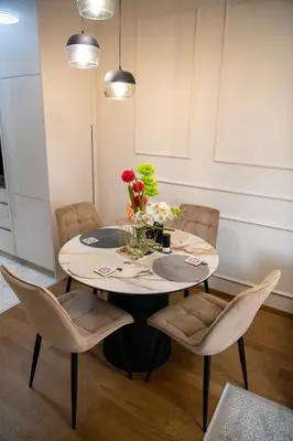 a dining room table with chairs and flowers on it at Harmony Space Apartment in Banja Luka