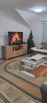 a living room with a tv and a christmas tree at LUX APARTMENT in Banja Luka