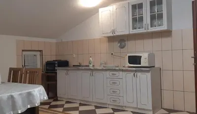 a kitchen with white cabinets and a microwave at LUX APARTMENT in Banja Luka