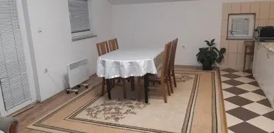 a table and chairs in a kitchen with a checkered floor at LUX APARTMENT in Banja Luka