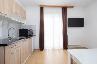 a kitchen with a sink and a microwave and a window at Apartman Ana in Kupres