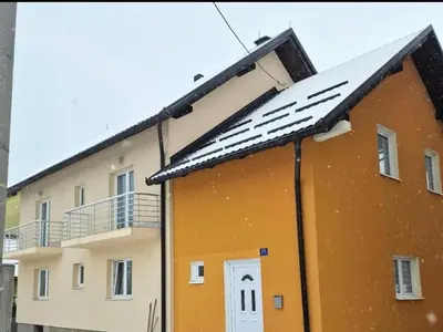 a building with snow on the roof at Apartman Ana in Kupres