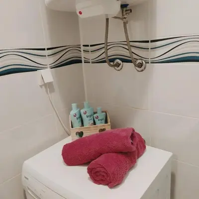 a pile of towels sitting on top of a washing machine at White home apartment in Banja Luka