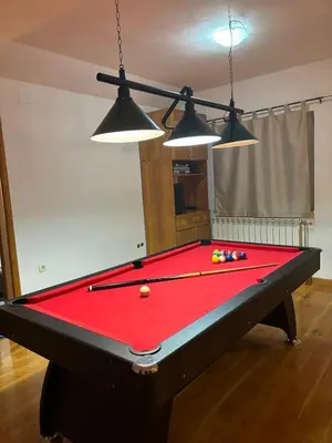 a pool table in a living room with three lights at VILLA M Rustic & Spa in Slatina Varoš