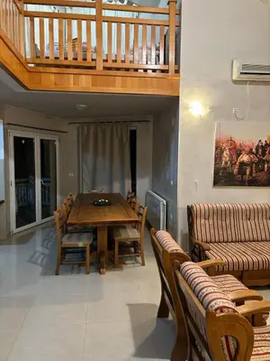 a dining room with a wooden table and chairs at VILLA M Rustic & Spa in Slatina Varoš