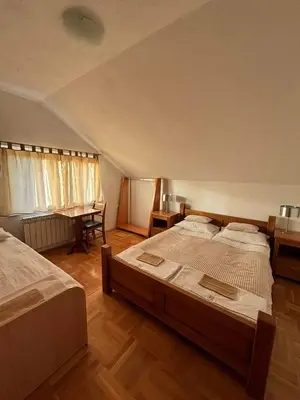 a large bedroom with two beds and a desk at VILLA M Rustic & Spa in Slatina Varoš