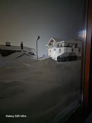 a car parked in front of a house in the snow at Apartmani Planinsko srce Vlašić in Vlasic