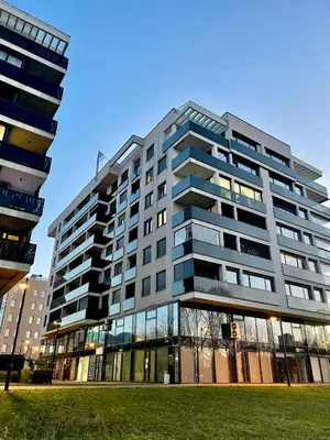 a large building with glass windows in a city at Stan Na Dan - Bewo River Apartments Banja Luka in Rebrovac
