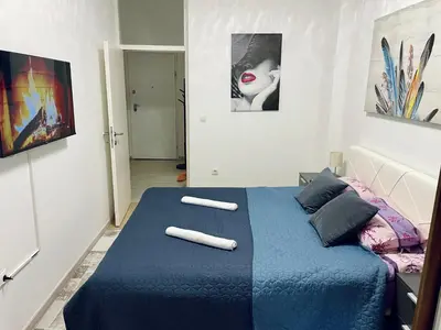a bedroom with a blue bed with two towels on it at Stan Na Dan - Bewo River Apartments Banja Luka in Rebrovac
