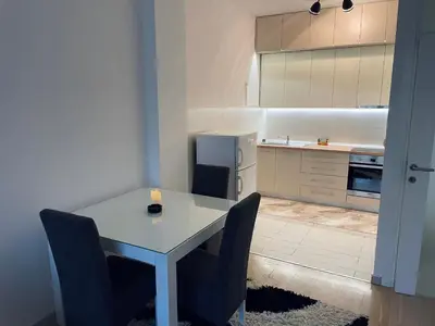 a kitchen with a table and chairs and a refrigerator at Stan Na Dan - Bewo River Apartments Banja Luka in Rebrovac