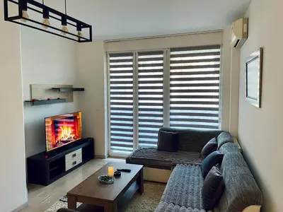 a living room with a couch and a tv at Stan Na Dan - Bewo River Apartments Banja Luka in Rebrovac