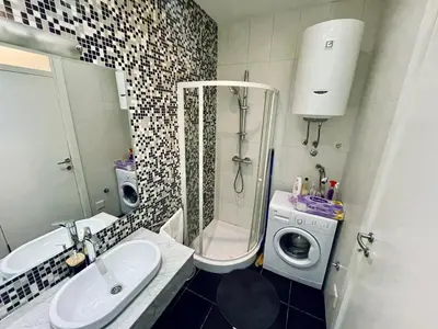 a bathroom with a sink and a washing machine at Stan Na Dan - Bewo River Apartments Banja Luka in Rebrovac