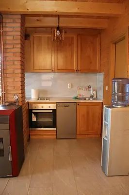a kitchen with wooden cabinets and a sink and a refrigerator at LAna in Šipovo
