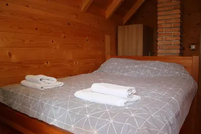 two towels on a bed in a wooden cabin at LAna in Šipovo