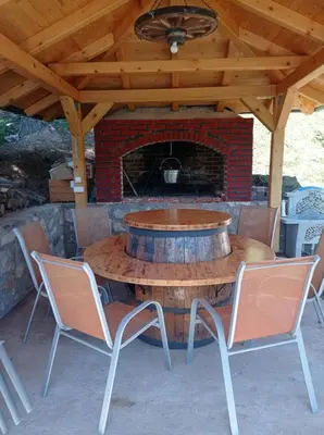 a wooden table with chairs and a fireplace at LAna in Šipovo