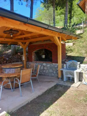 a patio with a fireplace and a table and chairs at LAna in Šipovo
