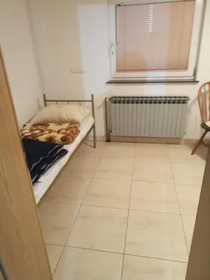 a bedroom with a bed and a tiled floor at Apartman SM IK 1 in Tomislavgrad