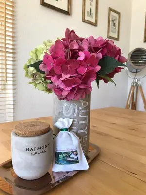 a vase with flowers and a candle on a table at Sokograd Loft in Šipovo
