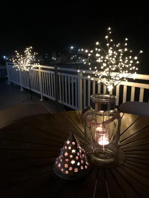 a glass jar with a candle on a table with lights at Sokograd Loft in Šipovo