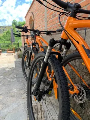 three orange bikes parked next to a brick building at Sokograd Loft in Šipovo