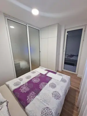 a bedroom with a bed with purple and white sheets at Apartment 4th. Floor II in Banja Luka