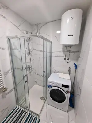 a bathroom with a shower and a washing machine at Apartment 4th. Floor II in Banja Luka
