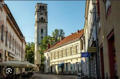 an old street with a clock tower in a city at Apartman PARK in Bihać