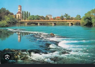 a bridge over a river with blue water at Apartman PARK in Bihać