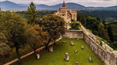 an old castle on a hill with animals in the grass at Apartman PARK in Bihać