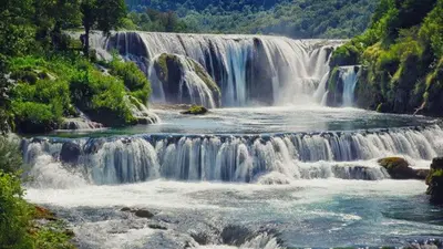 a waterfall in the middle of a river at Apartman PARK in Bihać