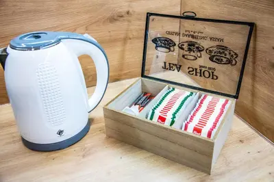 a tea kettle and a box of books on a table at Apartman Besta in Banja Luka