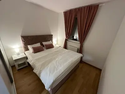a small bedroom with a bed and a window at Apartman Besta in Banja Luka